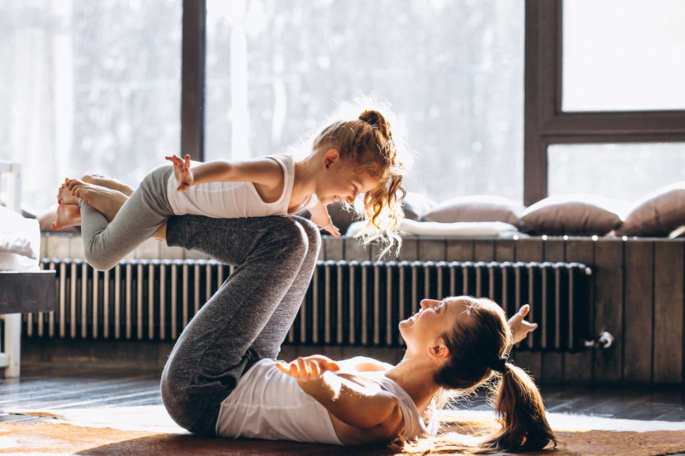 Mother and daughter doing a balancing exercise together at home, representing whole-body wellness and functional medicine support. Mother and daughter doing a balancing exercise together at home, representing whole-body wellness and functional medicine support.