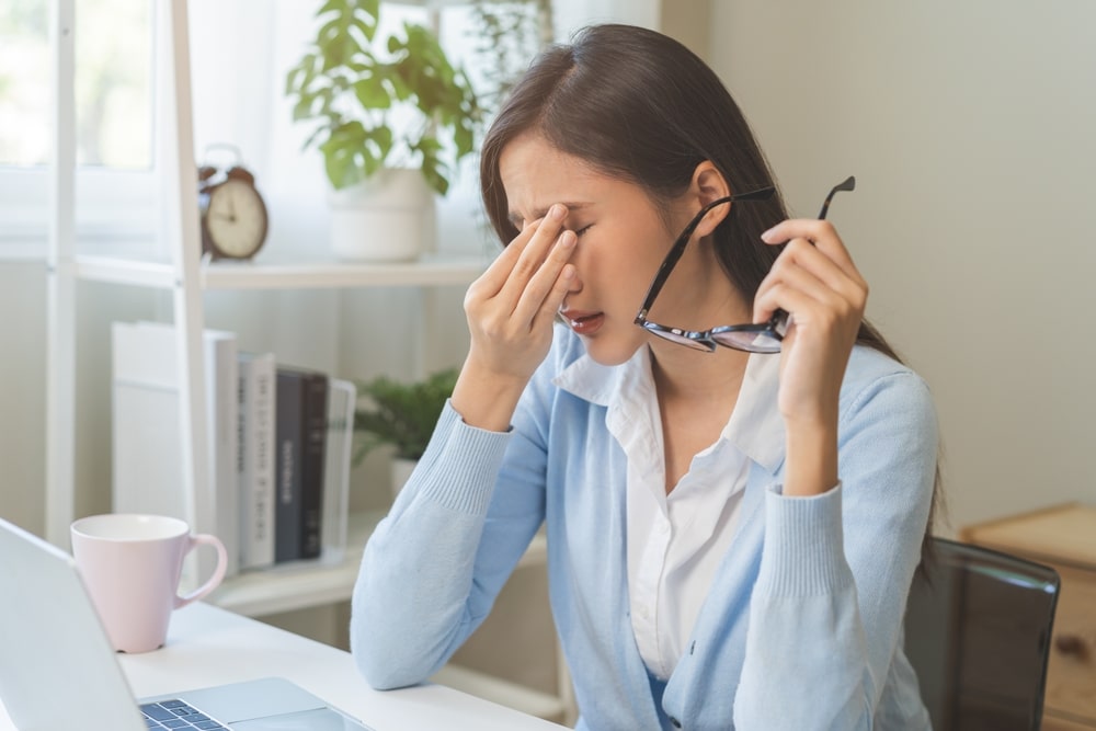 Tired woman with glasses rubbing her eyes while sitting at home. Tired woman with glasses rubbing her eyes while sitting at home.